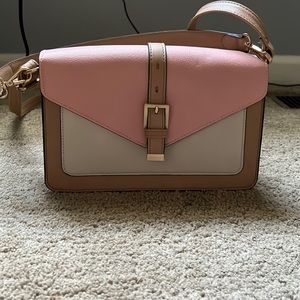 Pink, tan and white purse with long strap or shoulder strap.